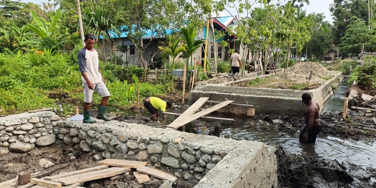 Di Tengah Lumpur dan Genangan Air, Satgas TMMD dan Warga Yamboi Tetap Semangat Bangun Jembatan